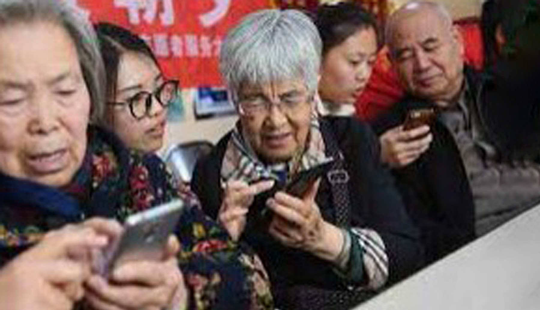 photograph showing seniors learning to use smart-phone